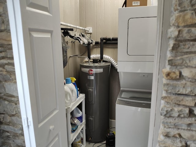 utility room with stacked washer / dryer and electric water heater