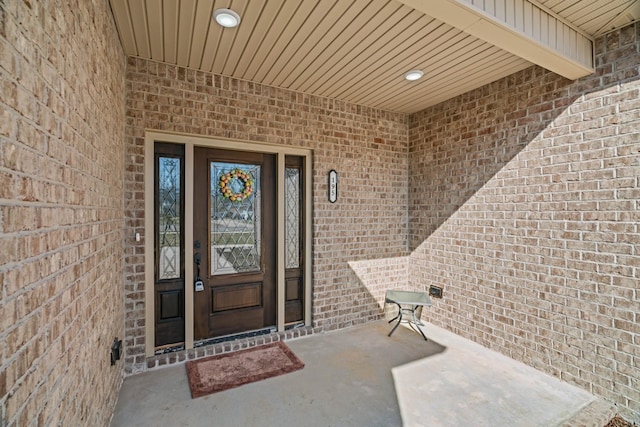 view of exterior entry featuring brick siding