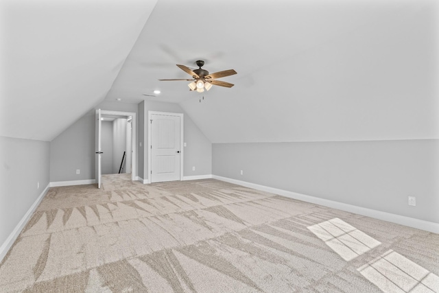 additional living space featuring ceiling fan, baseboards, vaulted ceiling, and light colored carpet