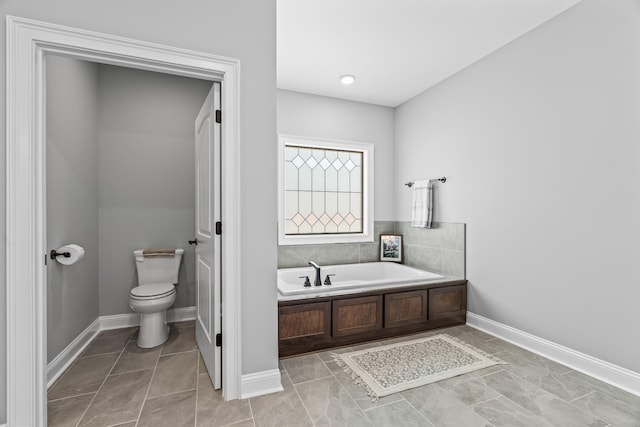 full bath featuring tile patterned floors, baseboards, toilet, and a bath