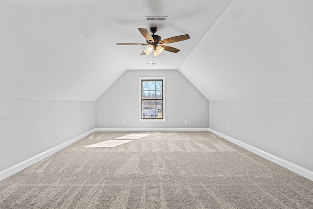 additional living space with a ceiling fan, visible vents, vaulted ceiling, baseboards, and carpet