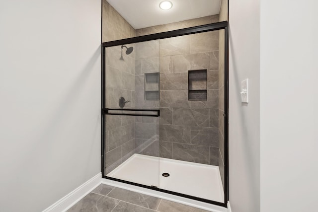 full bathroom featuring a stall shower and baseboards