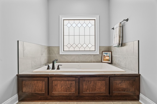 full bathroom featuring baseboards and a bath