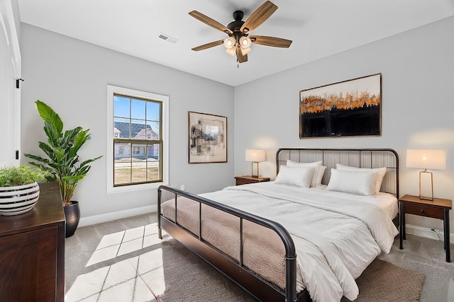 bedroom featuring a ceiling fan, light colored carpet, visible vents, and baseboards