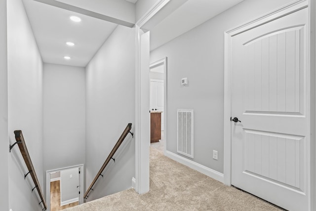 corridor with visible vents, baseboards, an upstairs landing, carpet floors, and recessed lighting