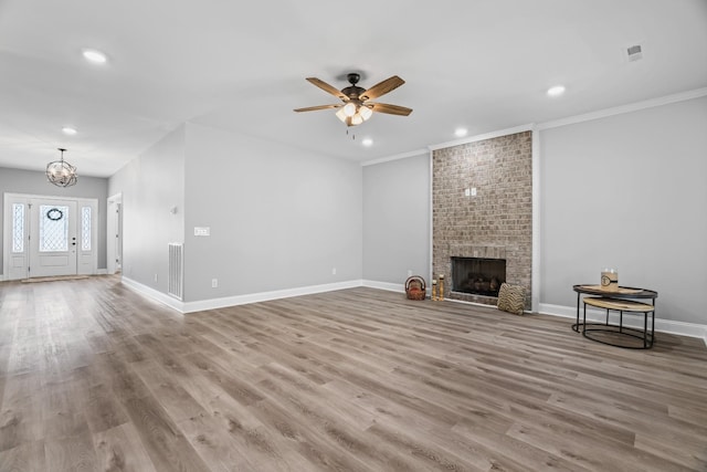 unfurnished living room featuring baseboards, a fireplace, visible vents, and wood finished floors