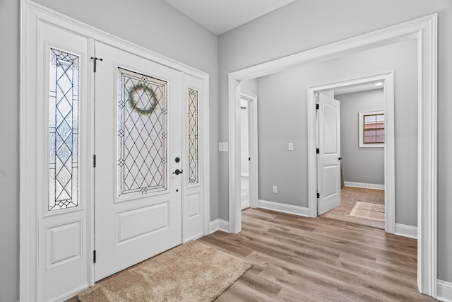 entryway featuring a wealth of natural light, light wood-type flooring, and baseboards