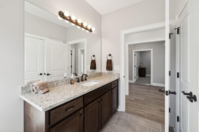 bathroom featuring tile patterned flooring, vanity, and baseboards