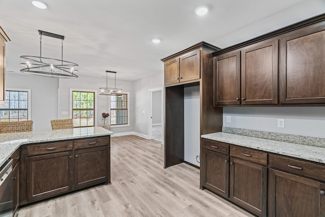 kitchen featuring light stone counters, light wood-style flooring, dark brown cabinetry, stainless steel dishwasher, and decorative light fixtures