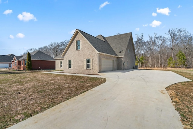 view of side of property featuring concrete driveway and brick siding