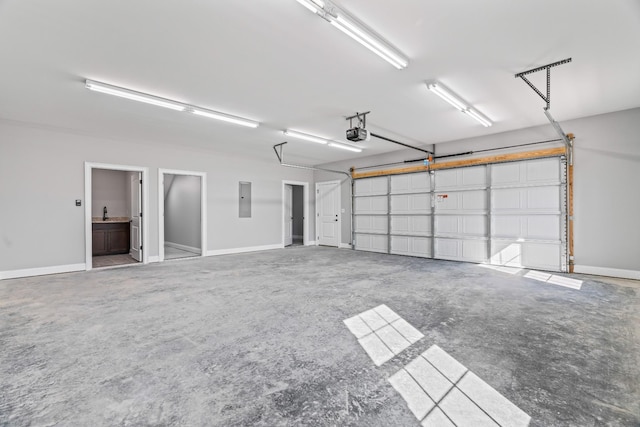 garage with a garage door opener, electric panel, and baseboards