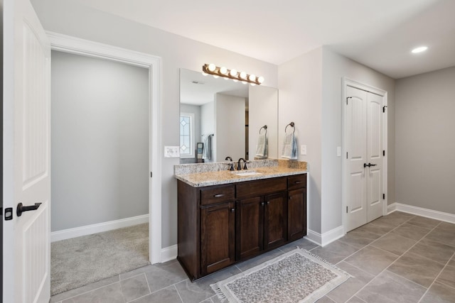 bathroom featuring tile patterned flooring, vanity, and baseboards