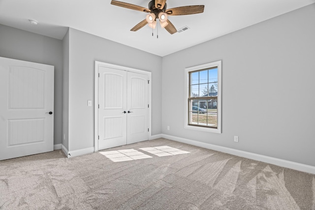 unfurnished bedroom featuring a closet, visible vents, carpet flooring, ceiling fan, and baseboards