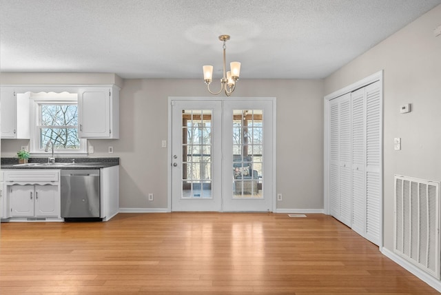 doorway featuring a textured ceiling, light wood-style flooring, a sink, and visible vents