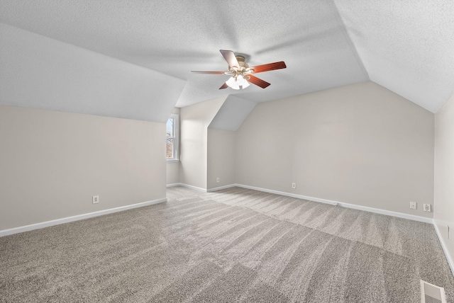 additional living space with baseboards, visible vents, and a textured ceiling