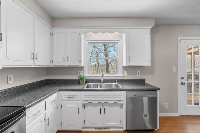 kitchen with a sink, dark countertops, visible vents, and dishwasher