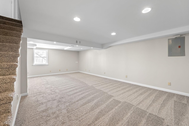 basement featuring electric panel, baseboards, stairway, carpet floors, and recessed lighting