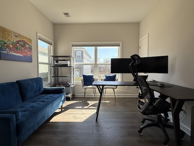 home office with wood finished floors, visible vents, and baseboards