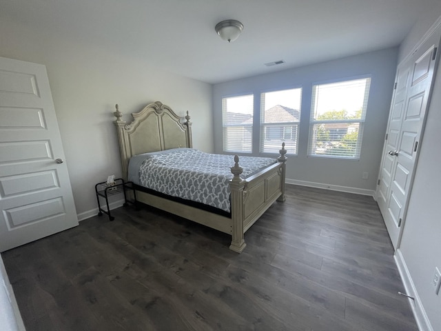 bedroom featuring dark wood-style floors, visible vents, and baseboards