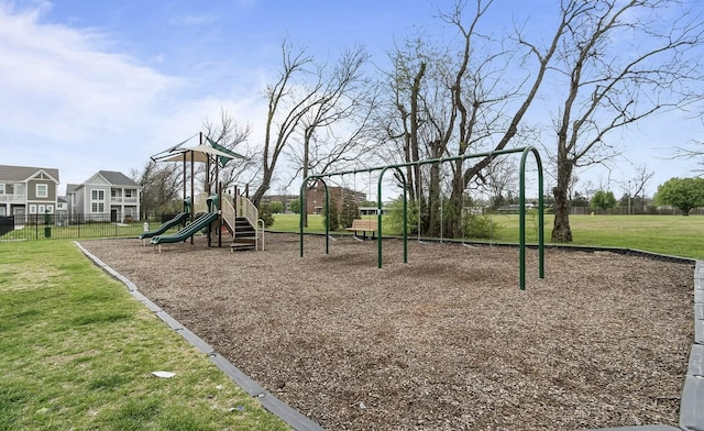 community play area featuring fence and a yard