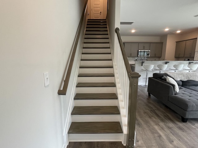 stairs featuring recessed lighting, visible vents, and wood finished floors