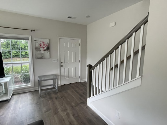 foyer entrance featuring dark wood-type flooring, visible vents, and baseboards