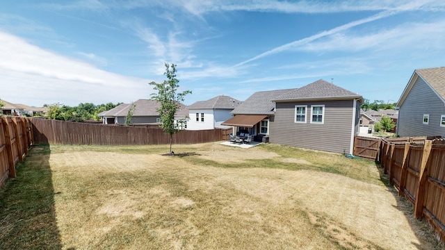 view of yard featuring a patio, a fenced backyard, and a residential view