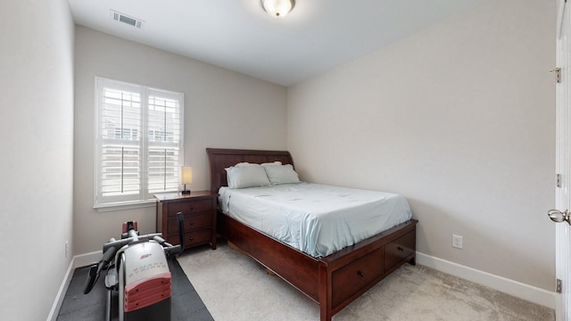 bedroom featuring visible vents, light carpet, and baseboards