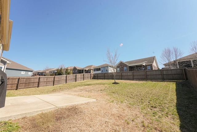 view of yard featuring a fenced backyard, a residential view, and a patio