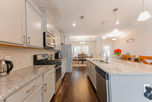 kitchen featuring a center island with sink, visible vents, dark wood-style floors, appliances with stainless steel finishes, and a sink