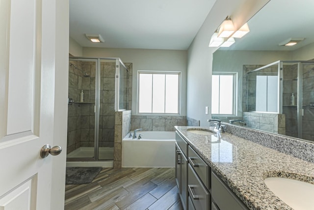 bathroom featuring double vanity, a sink, a bath, and a shower stall