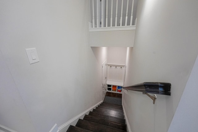 staircase with wood finished floors and baseboards