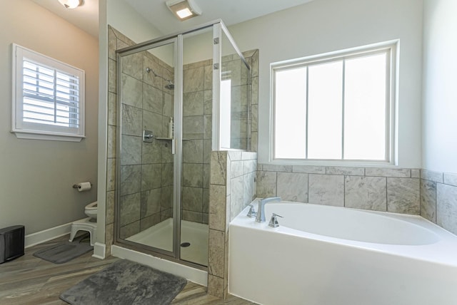 bathroom featuring a healthy amount of sunlight, a shower stall, and a bath