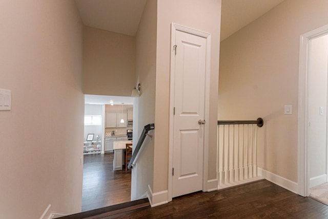 hall featuring dark wood finished floors and baseboards