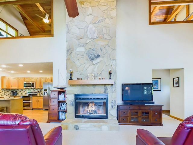 living room featuring high vaulted ceiling, a stone fireplace, wood ceiling, baseboards, and beamed ceiling