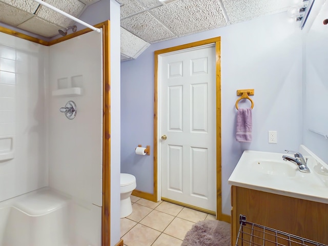 bathroom featuring a walk in shower, a drop ceiling, vanity, and tile patterned floors