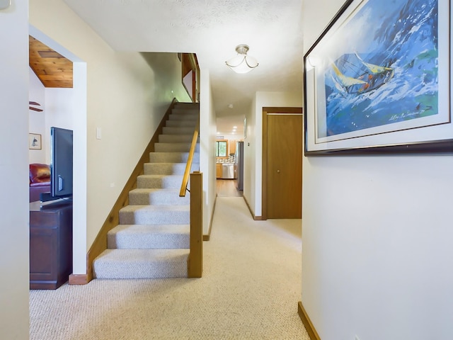 stairs featuring carpet and baseboards