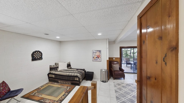 bedroom featuring recessed lighting, a wainscoted wall, light tile patterned flooring, and a drop ceiling