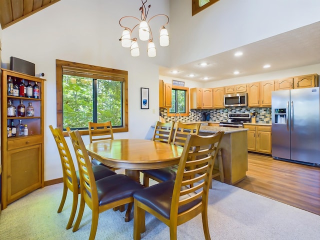 dining area featuring a chandelier, light wood-type flooring, a healthy amount of sunlight, and recessed lighting