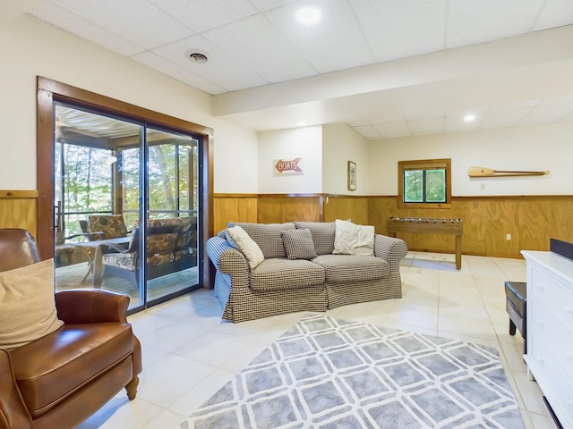 living area featuring plenty of natural light, wainscoting, and wooden walls