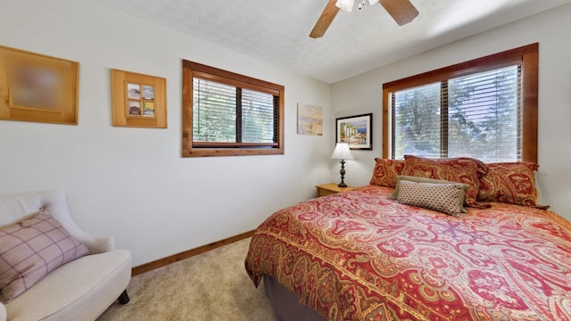 bedroom featuring a ceiling fan, carpet flooring, a textured ceiling, and baseboards