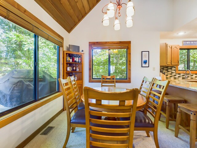 dining area with visible vents, an inviting chandelier, wood ceiling, vaulted ceiling, and baseboards