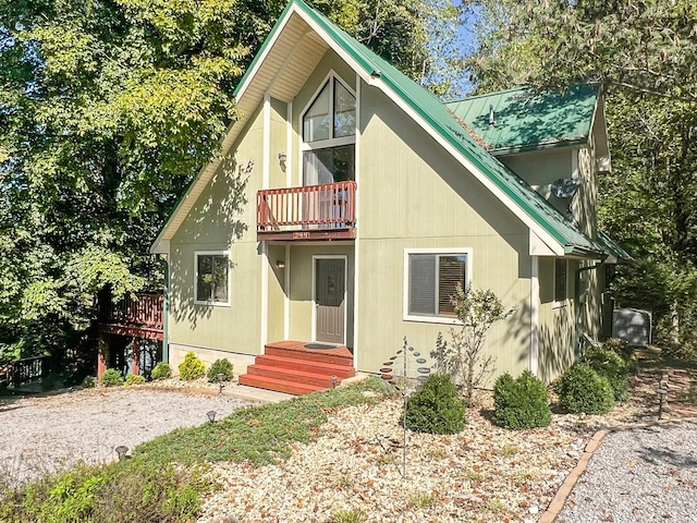 view of front of property with metal roof and a balcony