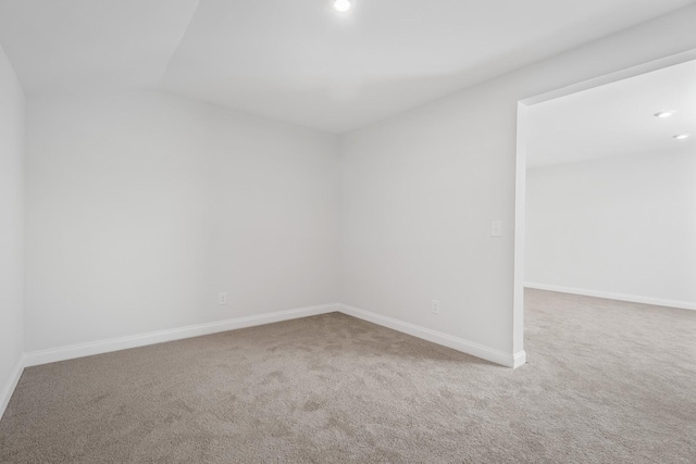 carpeted spare room featuring baseboards