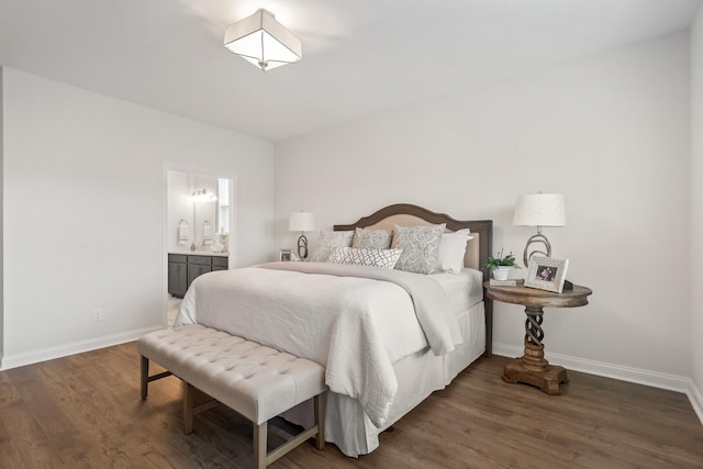 bedroom with connected bathroom, baseboards, and wood finished floors