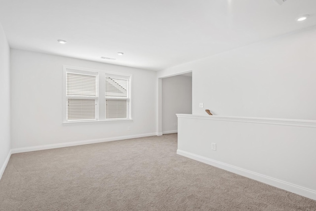 carpeted spare room featuring baseboards and recessed lighting