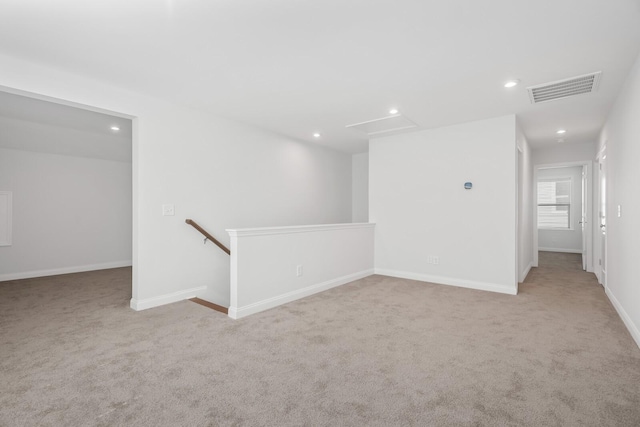 carpeted spare room featuring recessed lighting, visible vents, and baseboards