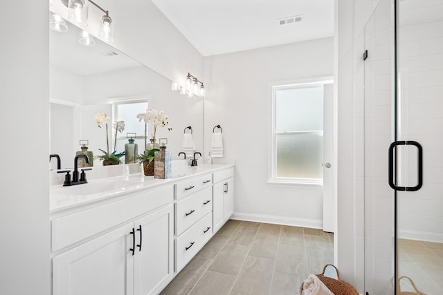 bathroom with double vanity, a sink, visible vents, and a shower stall