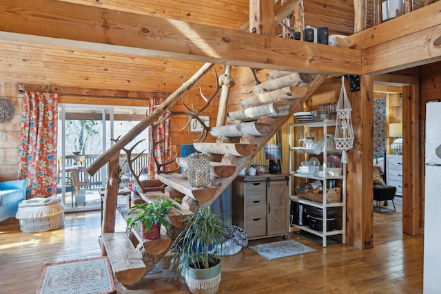 unfurnished living room featuring beamed ceiling, wood walls, and hardwood / wood-style flooring