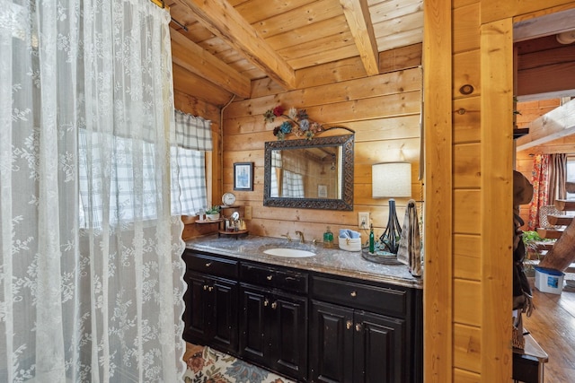 bathroom with wood ceiling, wood finished floors, beamed ceiling, vanity, and wood walls